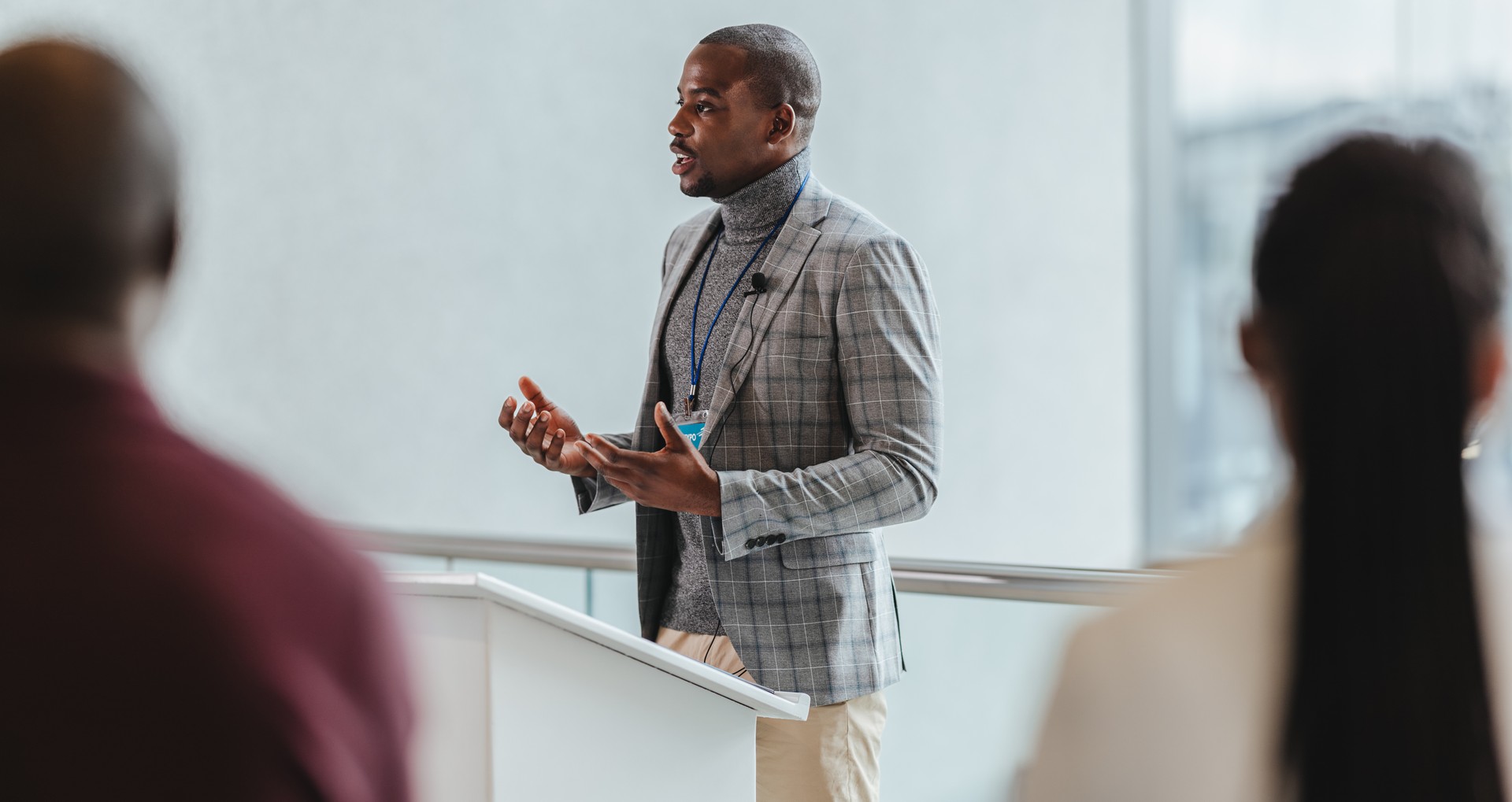 Businessman giving a presentation at a conference, engaged audience in modern office setting